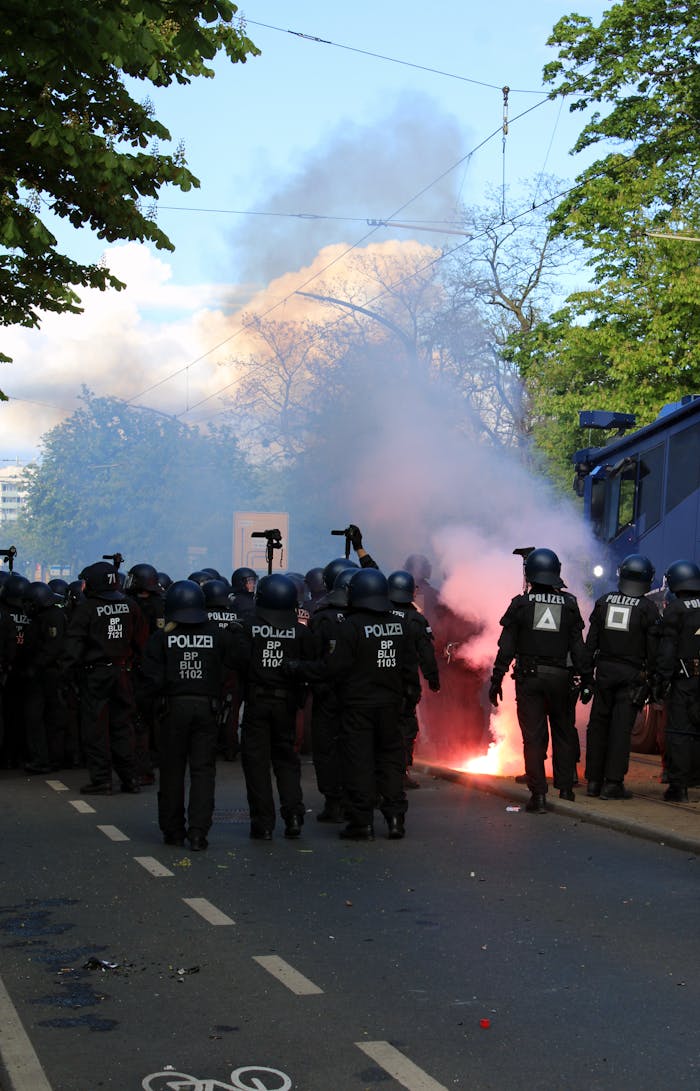 Police in riot gear handle a protest with smoke flares in Dresden, Germany.